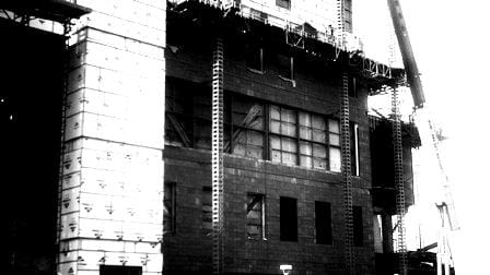 Black and white photo of Sun Valley Construction's building under construction with scaffolding and a crane visible.