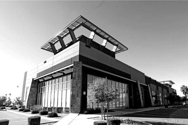 A black and white photograph of a modern commercial building by Sun Valley Construction with prominent geometric architectural features and surrounding landscaping.