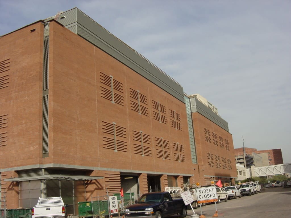 Large brick building with a pattern of vents, construction activity nearby, and a "street closed" sign visible.